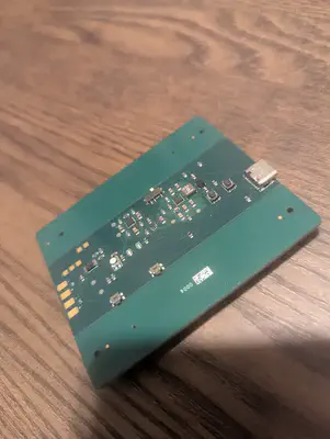 An assembled board photographed diagonally, showing the USB-C port, two pushbuttons, and components along the centre